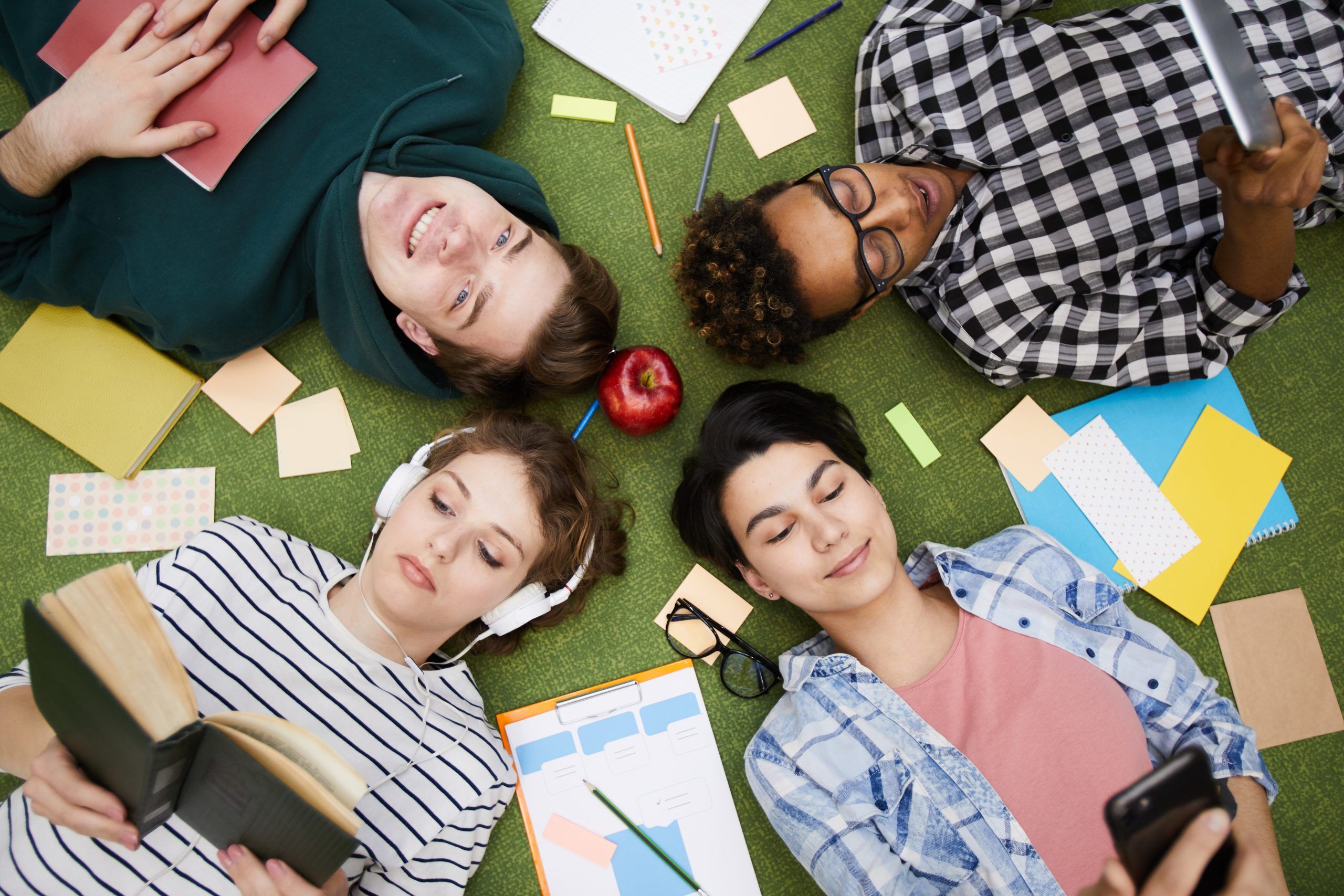 Modern students using gadgets and reading books